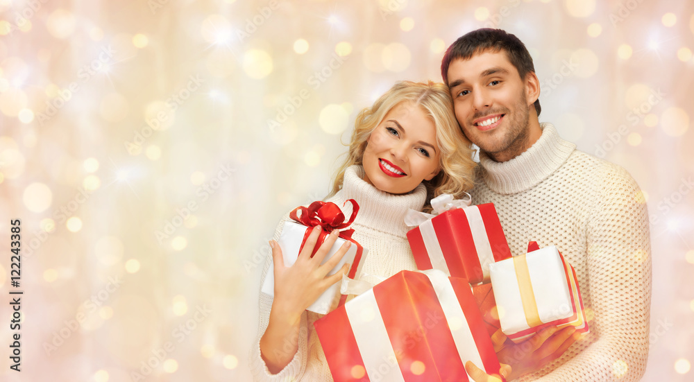 happy couple in sweaters holding christmas gifts happy couple in sweaters holding christmas gifts