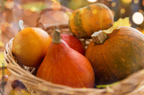 close up of pumpkins in basket on wooden table