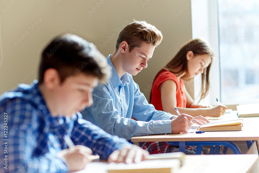 group of students with books writing school test