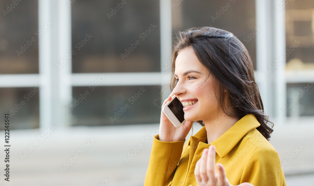 smiling young woman or girl calling on smartphone