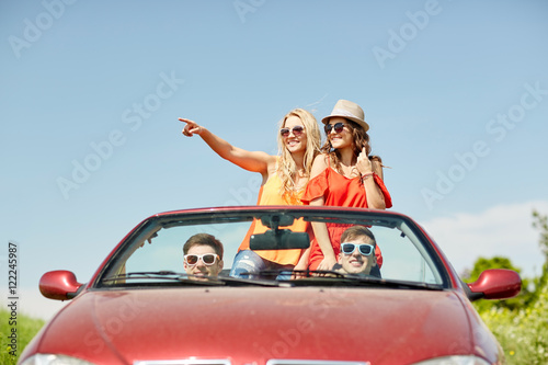 happy friends driving in cabriolet car at country © Syda Productions