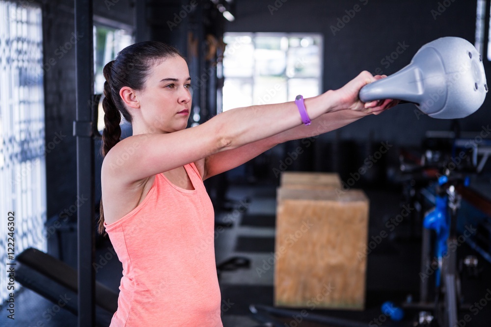 Female athlete holding kettlebell in gym Female athlete holding kettlebell in gym
