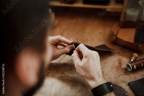  Close-up of the work. Portrait Male Master apron in his worksho photo