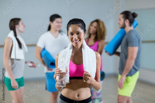 Portrait of woman holding water bottle and towel