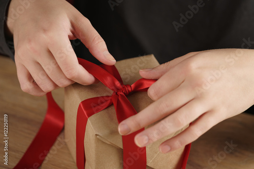 packing presents with red ribbon