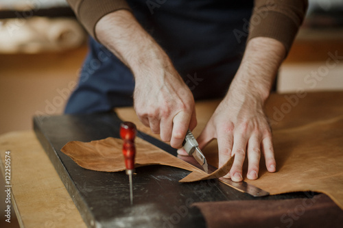 Close-up. Male hand master work with the skin. Small business