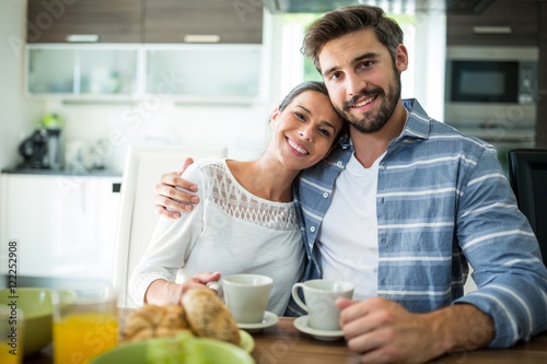 Portrait of couple sitting with arm around