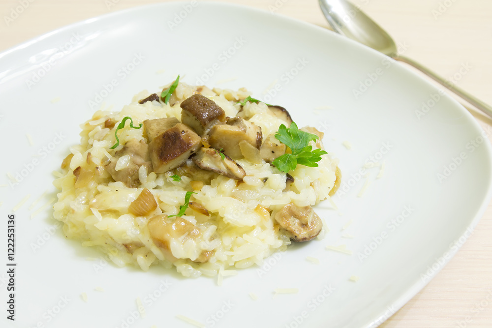 Risotto with mushrooms, parmesan cheese and parsley on a wooden background Risotto with mushrooms, parmesan cheese and parsley on a wooden background
