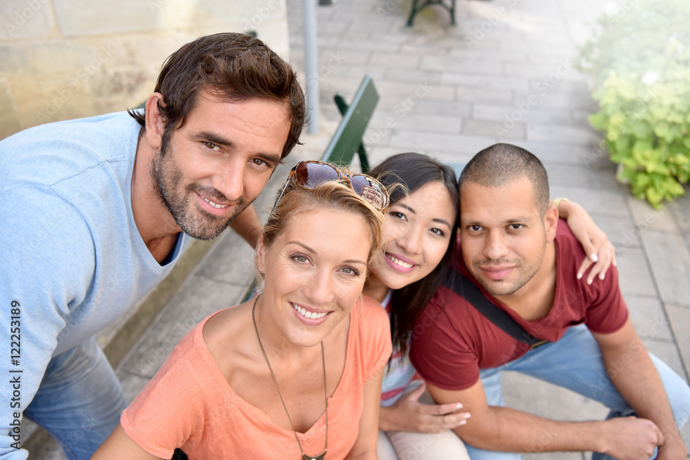 Portrait of four young adults sitting on bench in town Portrait of four young adults sitting on bench in town