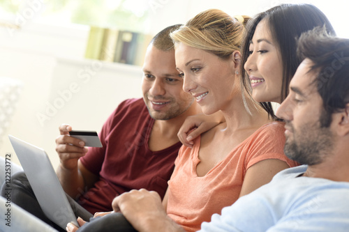 Group of friends using laptop and buying online, e-shopping