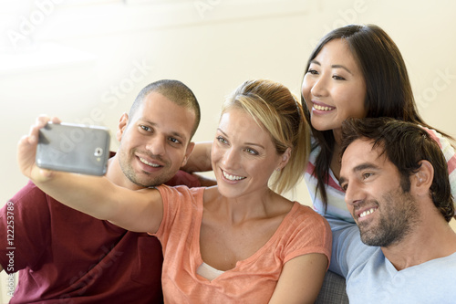 Group of friends taking selfie pictures with smartphone