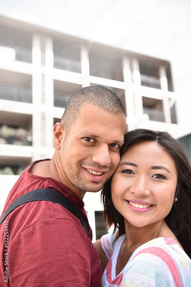 Mixed-race couple embracing each other in town Mixed-race couple embracing each other in town