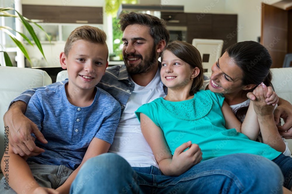 Happy family sitting with arm around on sofa Happy family sitting with arm around on sofa