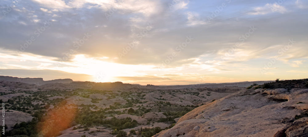 Desert sunset panorama with clouds and brush and stone