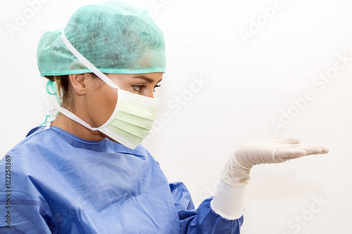 Surgeon looking at something on her hand