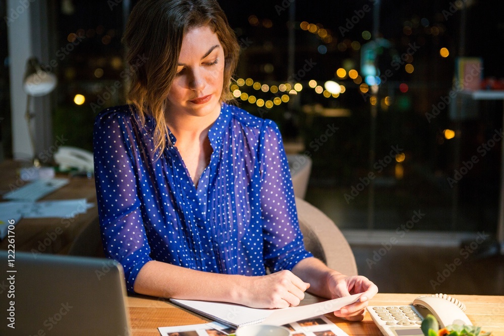 Fototapeta premium Businesswoman reading document at her desk