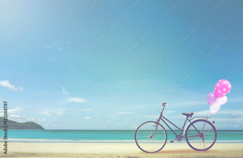 Fototapeta premium vintage bicycle on white sand beach over blue sea and clear blue sky background, spring or summer holiday vacation concept. 