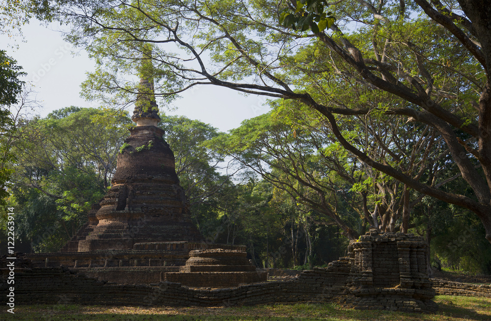 The ancient Chedi of Wat Nang Phaya in the rainforest. Si-Satchanalai, Thailand