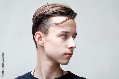 Young man profile face on grey