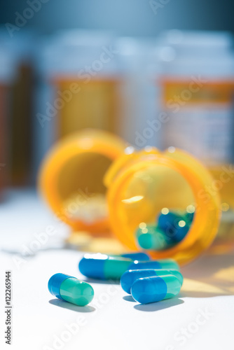 Obraz na płótnie Antiviral antidepressant blue green capsules pills spill out of prescription bot