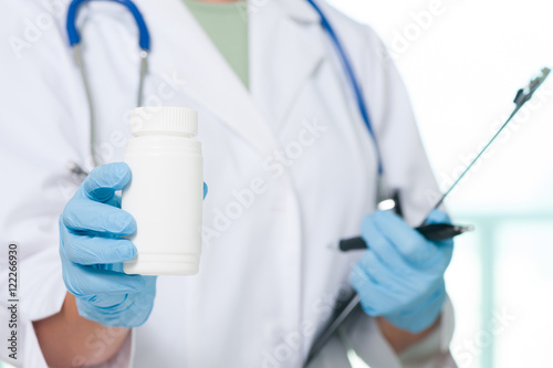 Female doctor holding pill bottle