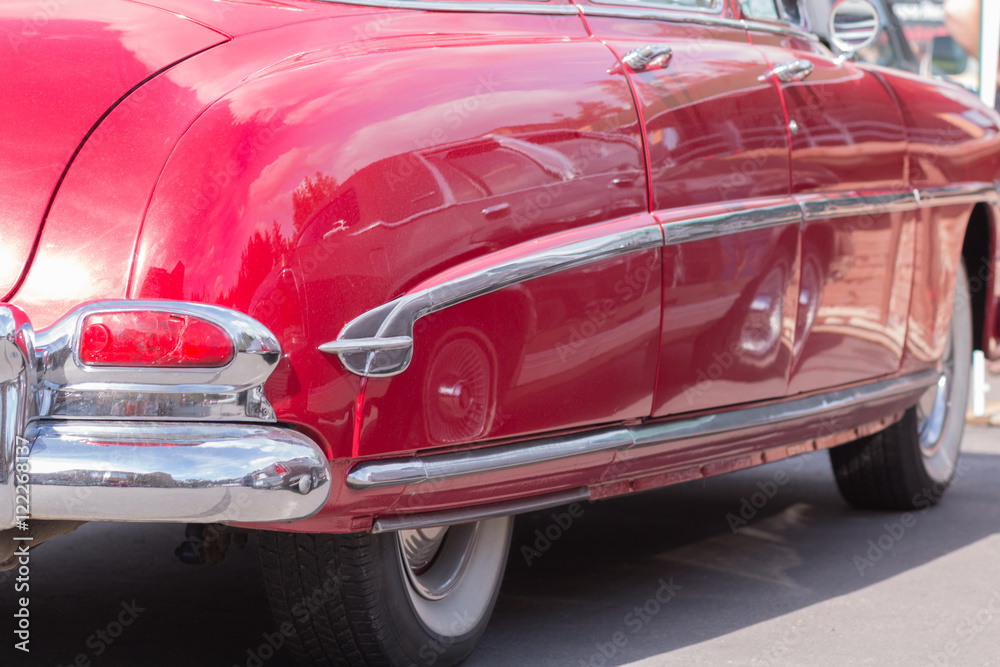 Close-up of an old car. Part of the exterior. An American classic. Chrome lining. Glass with reflection.