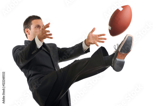 Obraz na plátně Businessman Kicking American Football on White