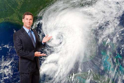 Television meteorologist weatherman forcasting with hurricane typhoon cyclone image in background