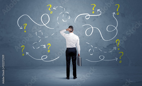 Foto Unsure businessman with question marks