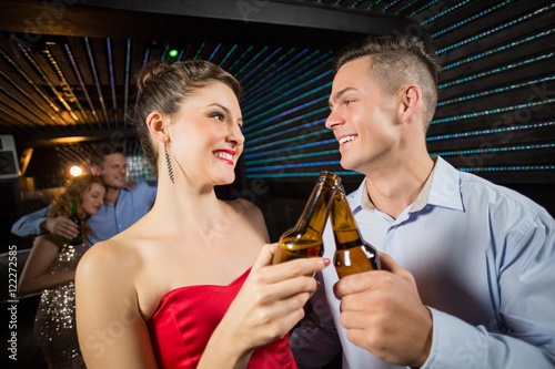 Happy couple toasting a beer bottles Fototapet