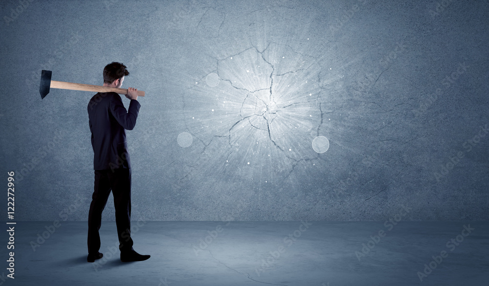 Business man hitting wall with a hammer Business man hitting wall with a hammer