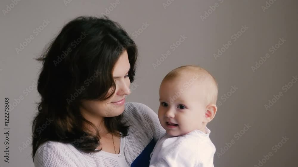 Young Happy Mother Holding her Newborn Child. Family at home. Beautiful smiling Mom and Happy Baby Together. Young Happy Mother Holding her Newborn Child. Family at home. Beautiful smiling Mom and Happy Baby Together.