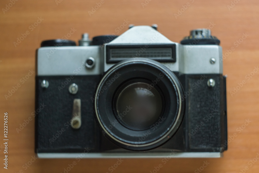 Old camera and slides on the wooden background