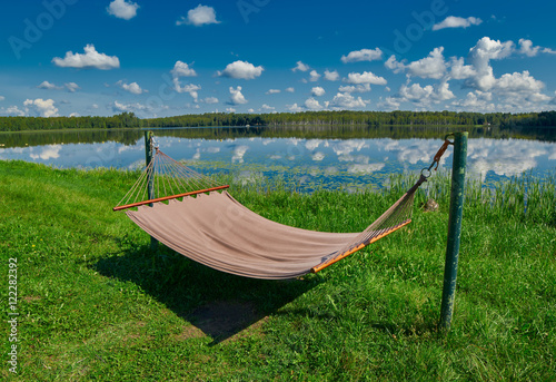 Relaxing Hammock on a lake shore under summer sunshine