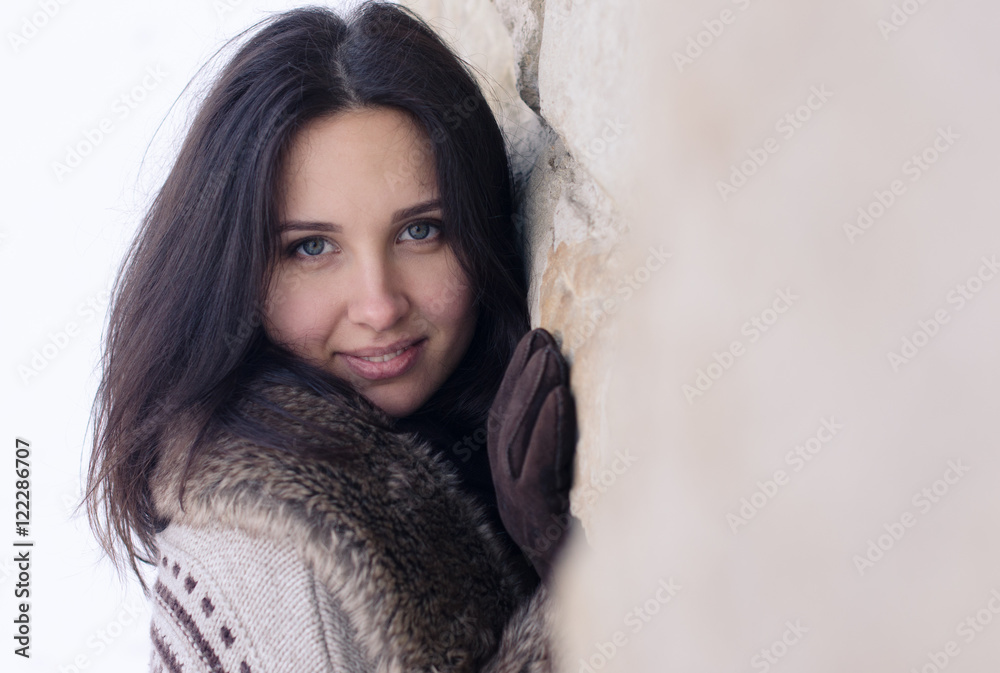 Portrait of a beautiful girl near the wall in winter Portrait of a beautiful girl near the wall in winter