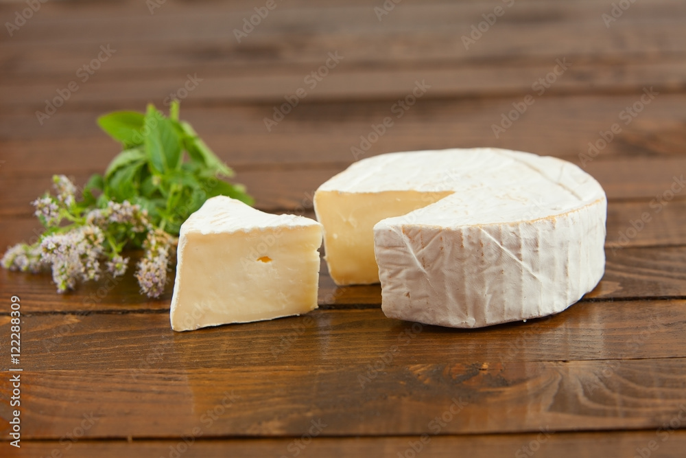 Fresh brie cheese with white mold on a white background