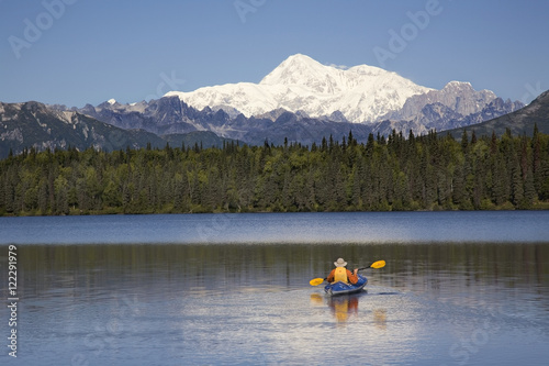 Man Paddling A Klepper Kayak On Byers Lake At Denali State Park. Mt. Mckinley Is Visible In The Background. August. Summer In The Interio Of Alaska. photo