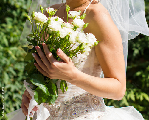 Bride holding wedding bouquet with roses