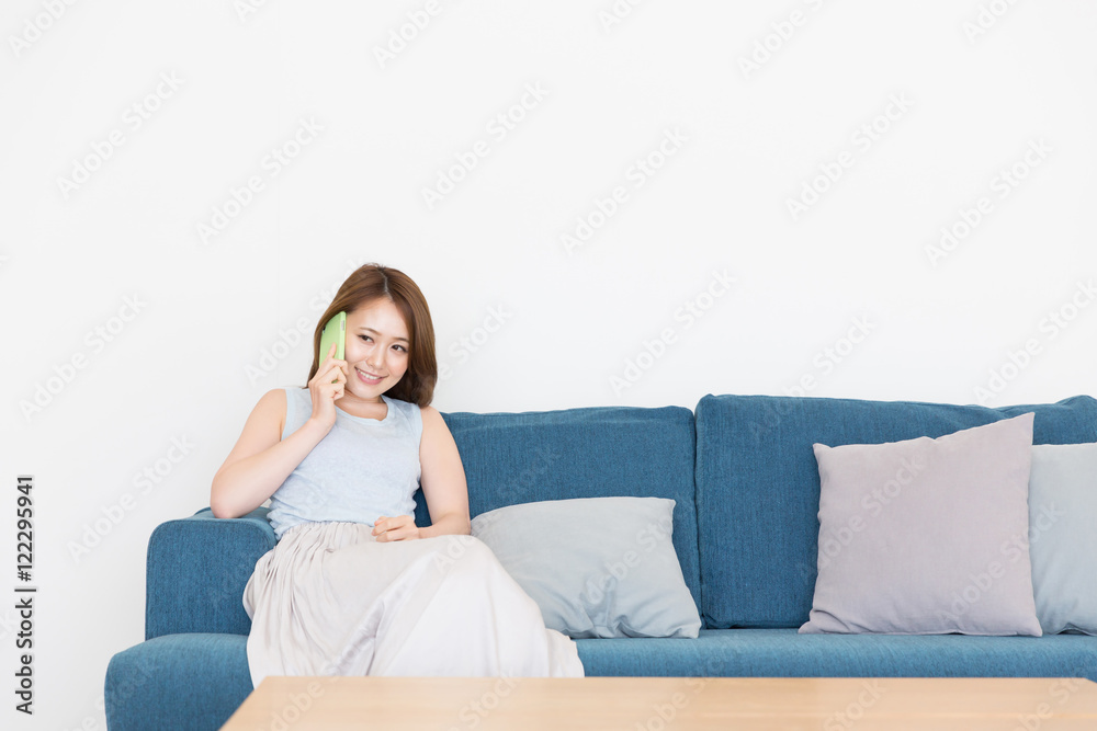 部屋で電話をする女性 部屋で電話をする女性