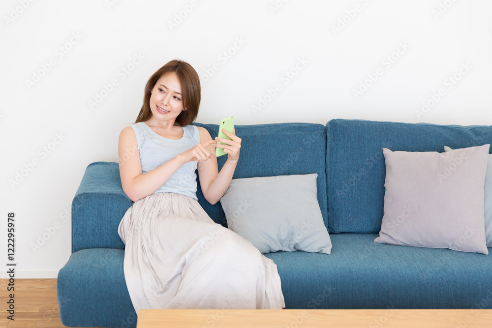 部屋でスマホを見る女性 部屋でスマホを見る女性