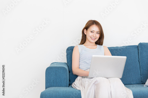 部屋でパソコンを見る女性