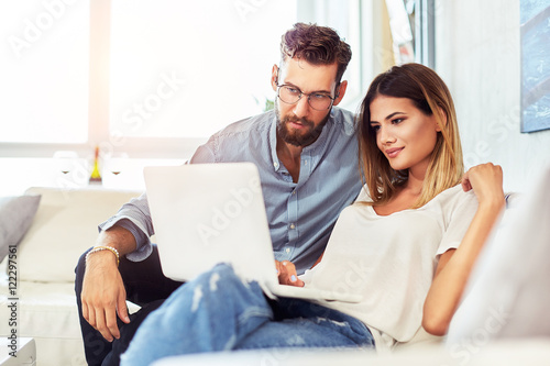 Young couple sitting on the sofa and surf the Internet