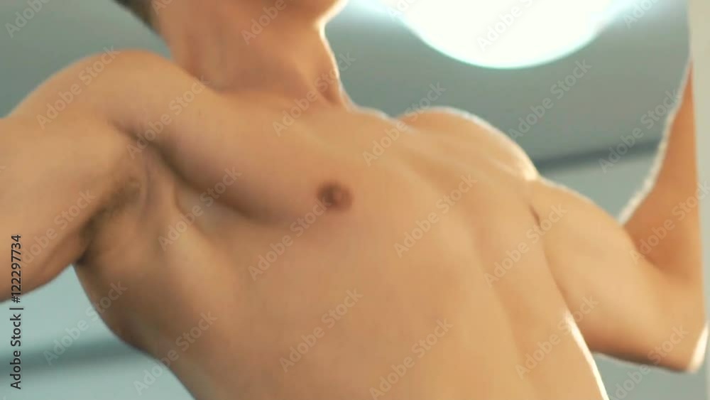 Young muscular athlete pull-ups in the gym Young muscular athlete pull-ups in the gym
