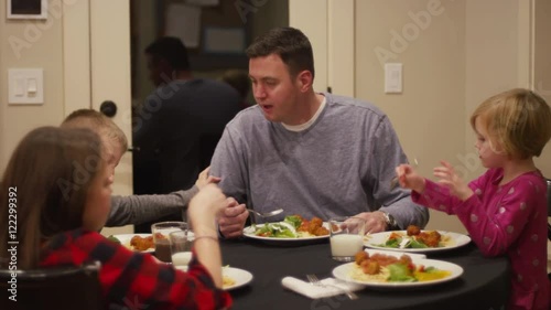 A family sitting down to have spaghetti and meatballs for dinner