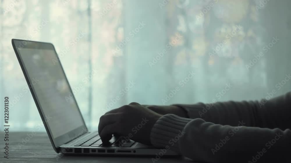Man hands typing on a keyboard using his laptop computer Man hands typing on a keyboard using his laptop computer