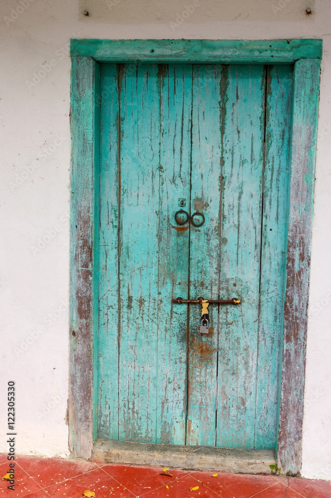 closed old blue wooden door. Mediterranean style exterior.