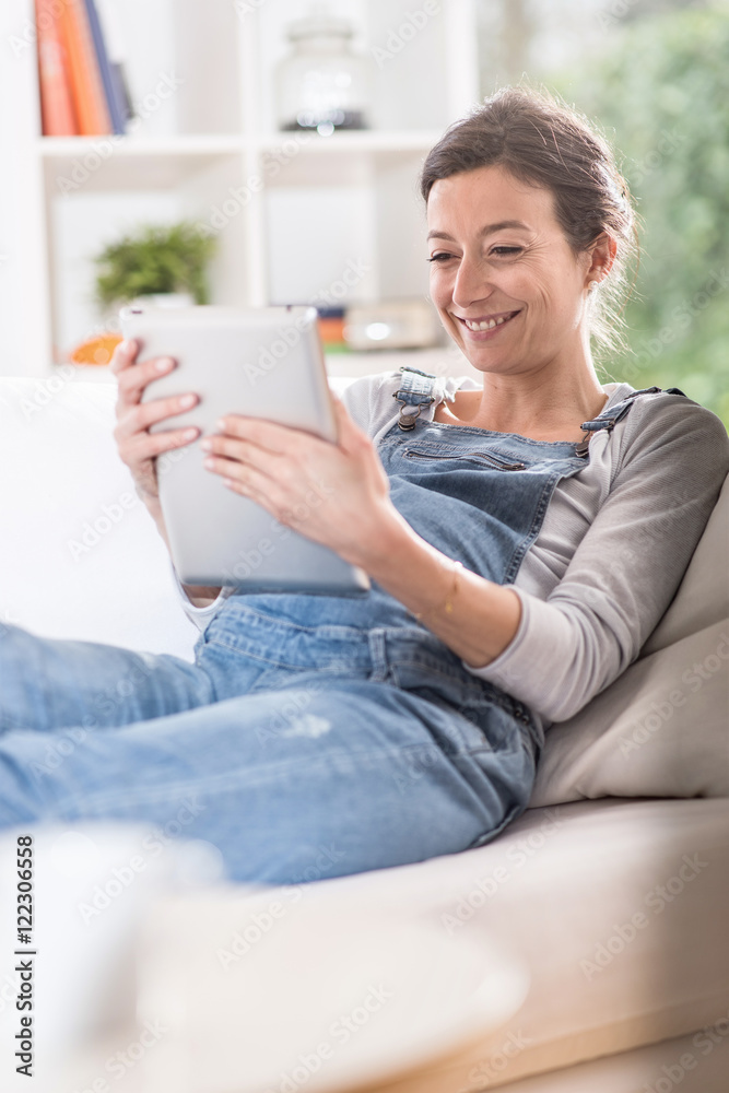 young pregnant woman at home using a tablet young pregnant woman at home using a tablet