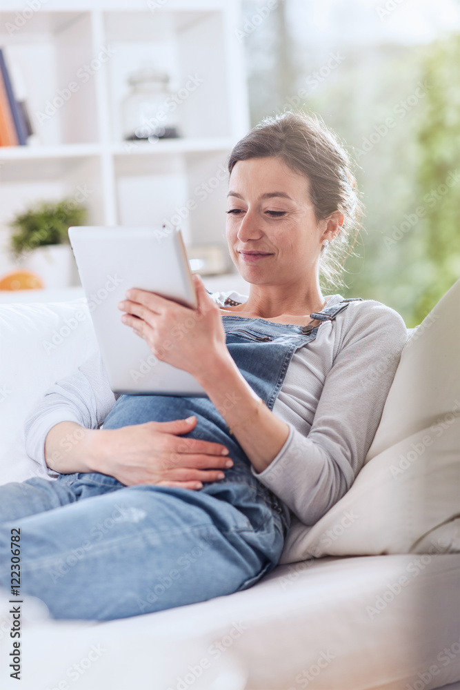 young pregnant woman at home using a tablet young pregnant woman at home using a tablet