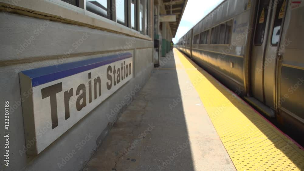Train passing the station sign