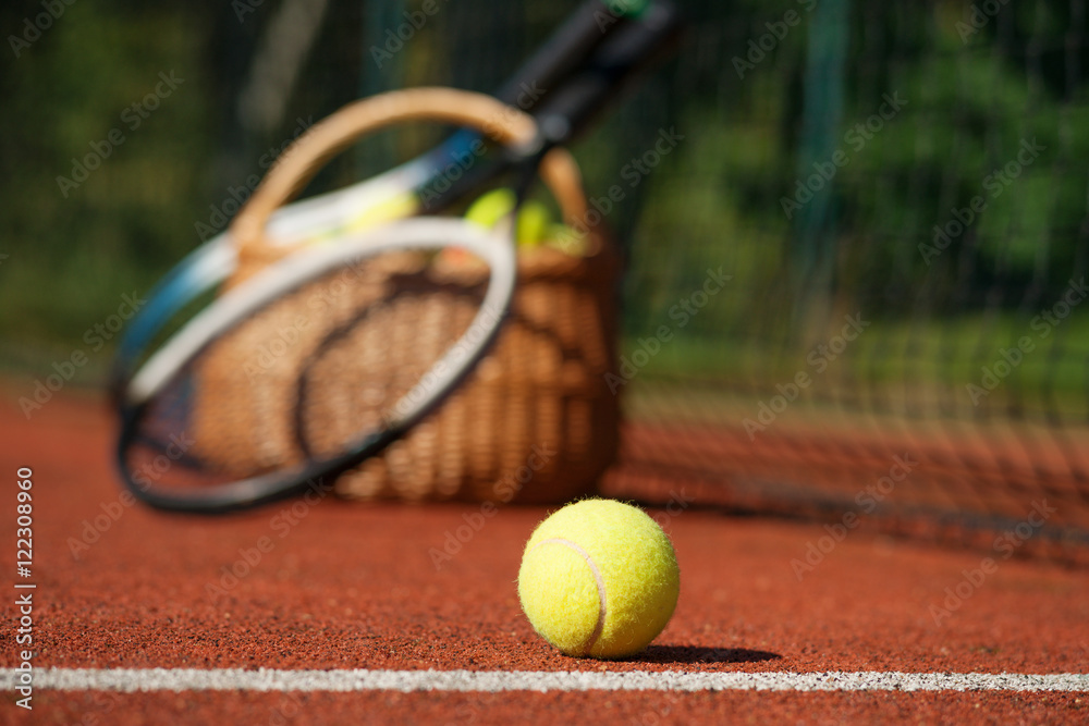 Tennis rackets and ball on court 